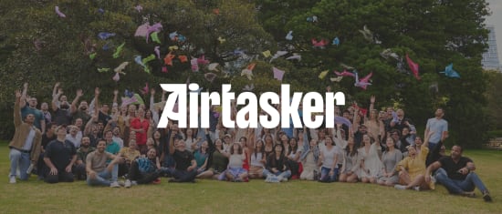 Airtasker team celebrating outdoors, throwing colorful fabric above them in a joyful group photo., Airtasker group photo, Celebration outdoors