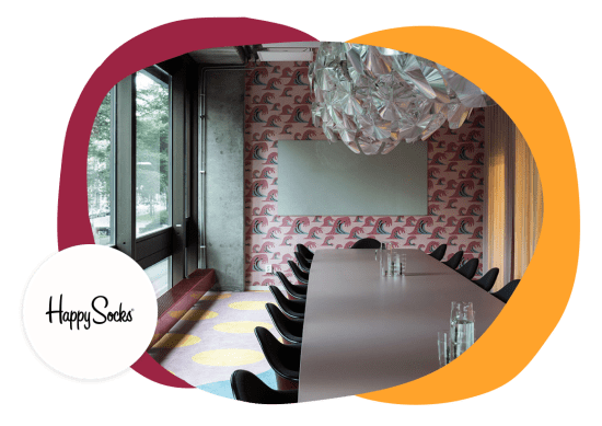 meeting room interior with colorful wave wallpaper and modern chandelier, Happy Socks branding visible on wall decoration