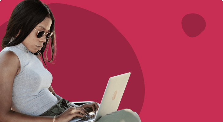 woman using laptop outdoors, stylish sunglasses and casual outfit against vibrant background