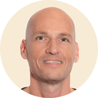 bald man smiling, close-up portrait with neutral background