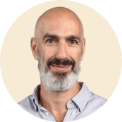 bearded man smiling in light shirt, neutral background, professional portrait with round frame, friendly expression